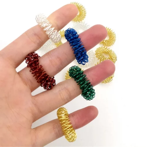 Anneau sensoriel picots sur doigt enfant montrant taille adaptable massage anti-stress TDAH