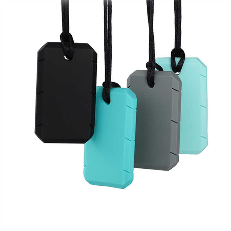 Quatre pendentifs à mâcher en plaque de silicone suspendus par leur cordon noir : un noir, un gris et deux verts