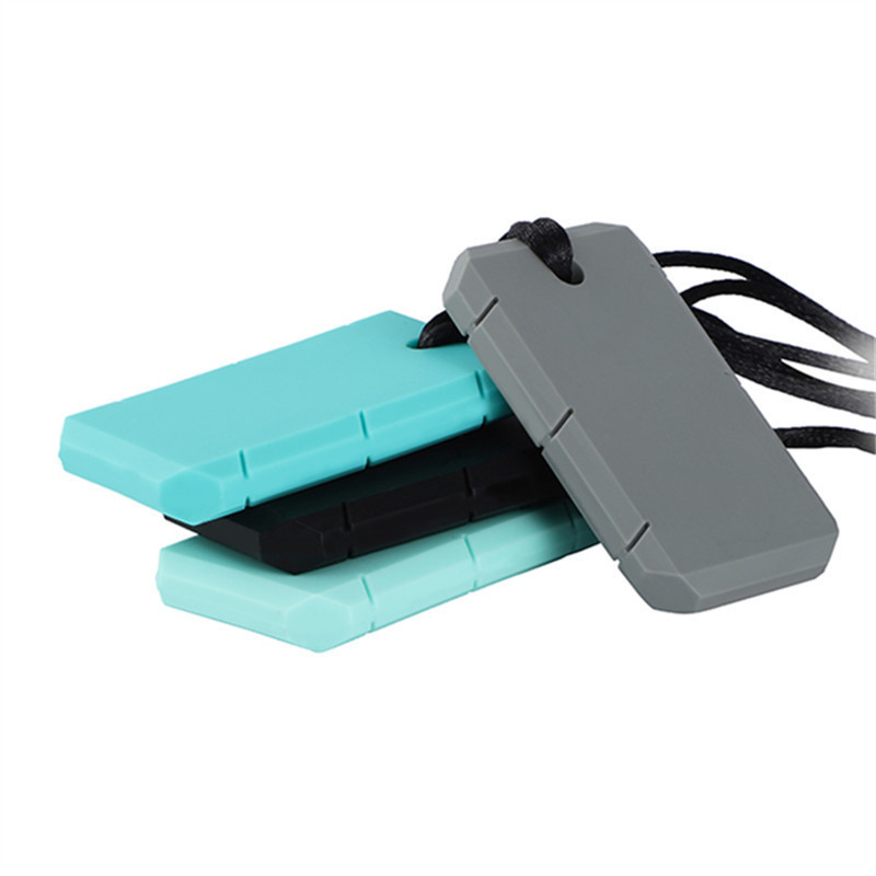 Trois plaques de silicone superposées, vert, gris et noir, cordons visibles