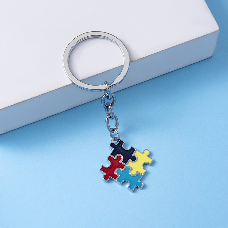 Porte-clés puzzle autisme tenu dans la main