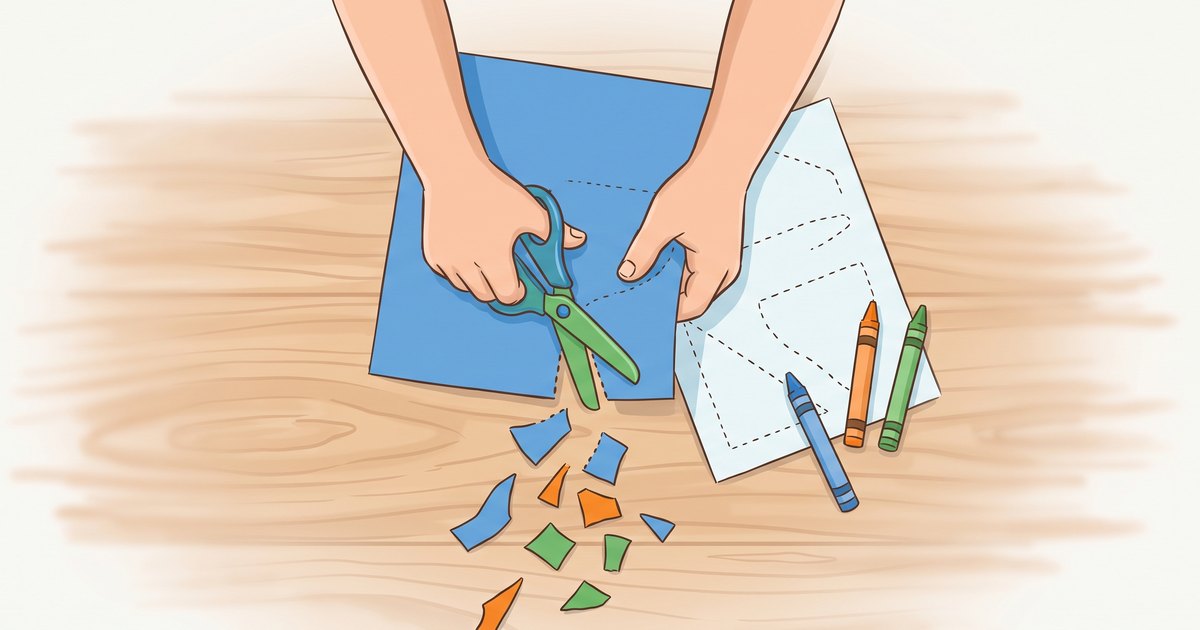 Mains d enfant decoupant du papier colore avec des ciseaux securises sur une table en bois