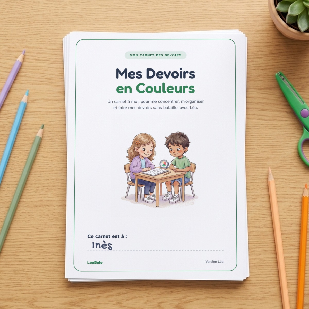 Couverture du carnet Mes Devoirs en Couleurs, imprimée, sur une pile de feuilles : Léa et Léo à leur table de travail, un minuteur entre eux